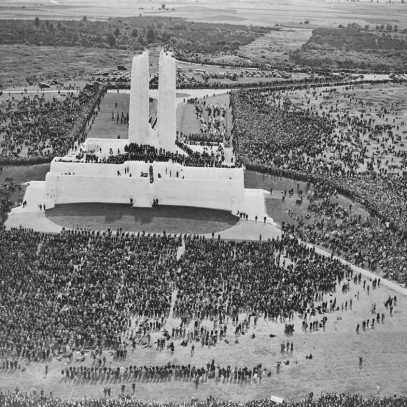 Black and white photograph. Aerial view of the monument and crowd surrounding it. The iconic Mother Canada sculpture is covered by dark cloth.